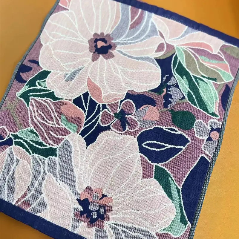 Floral patterned fabric with white flowers and green leaves on a wooden surface