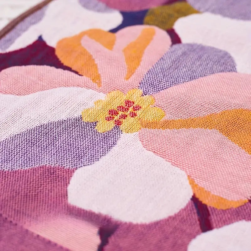 Close-up of a colorful floral fabric pattern with pink, orange, and purple colors.