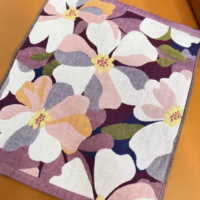 Floral patterned rug with pink, white, and purple flowers on a wooden floor.