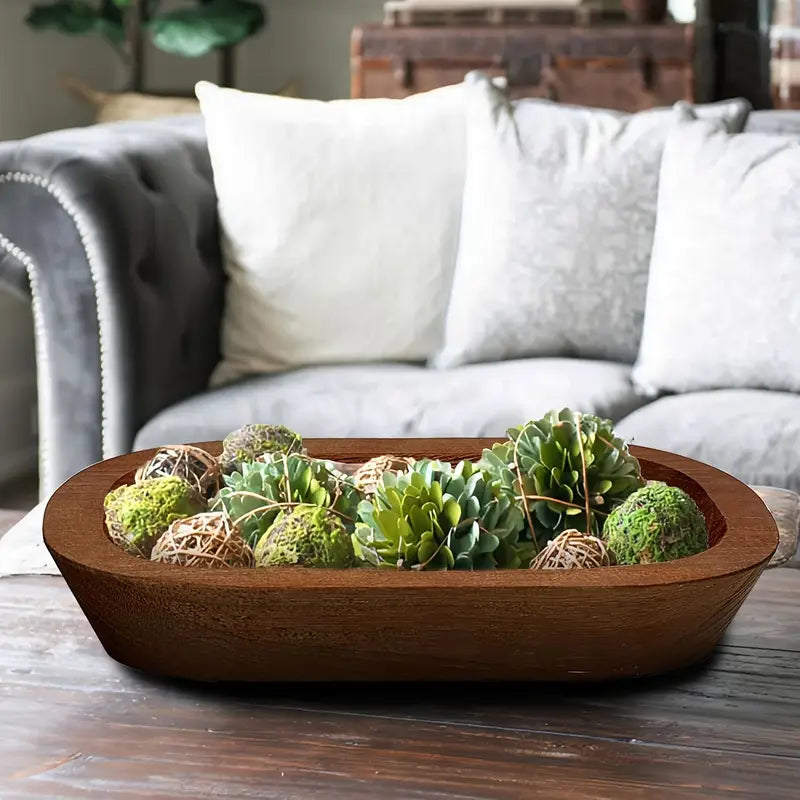 Decorative bowl with succulents on a wooden table in a living room setting