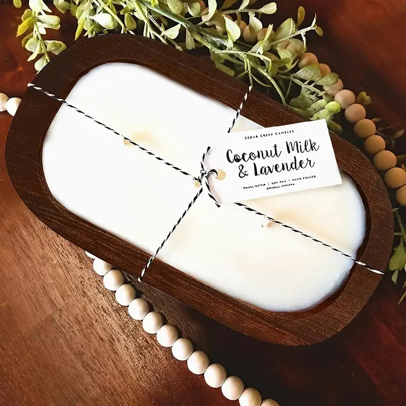 Coconut milk and lavender candle in a wooden holder with a label on a wooden surface.