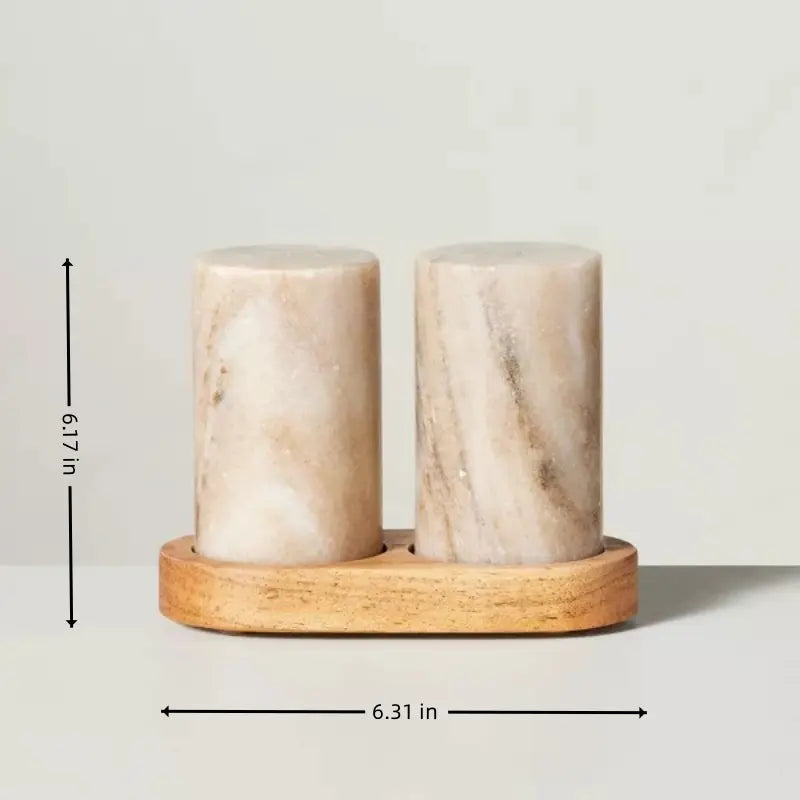 Marble salt and pepper shakers with wooden base on a light gray background