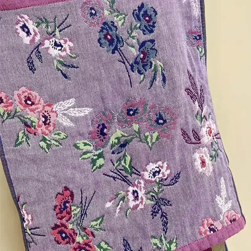 Embroidered floral pattern on a fabric with a light purple background