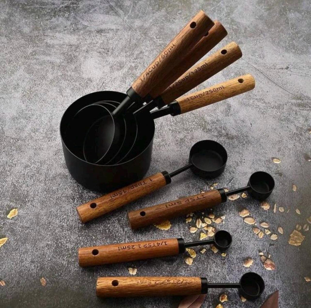 Set of measuring cups with wooden handles on a gray surface