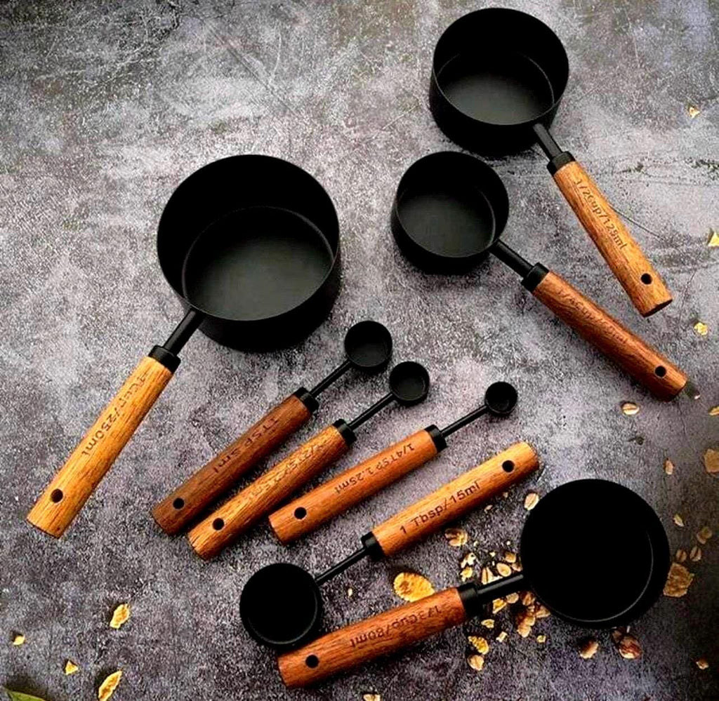 Set of measuring cups and spoons with wooden handles on a textured surface