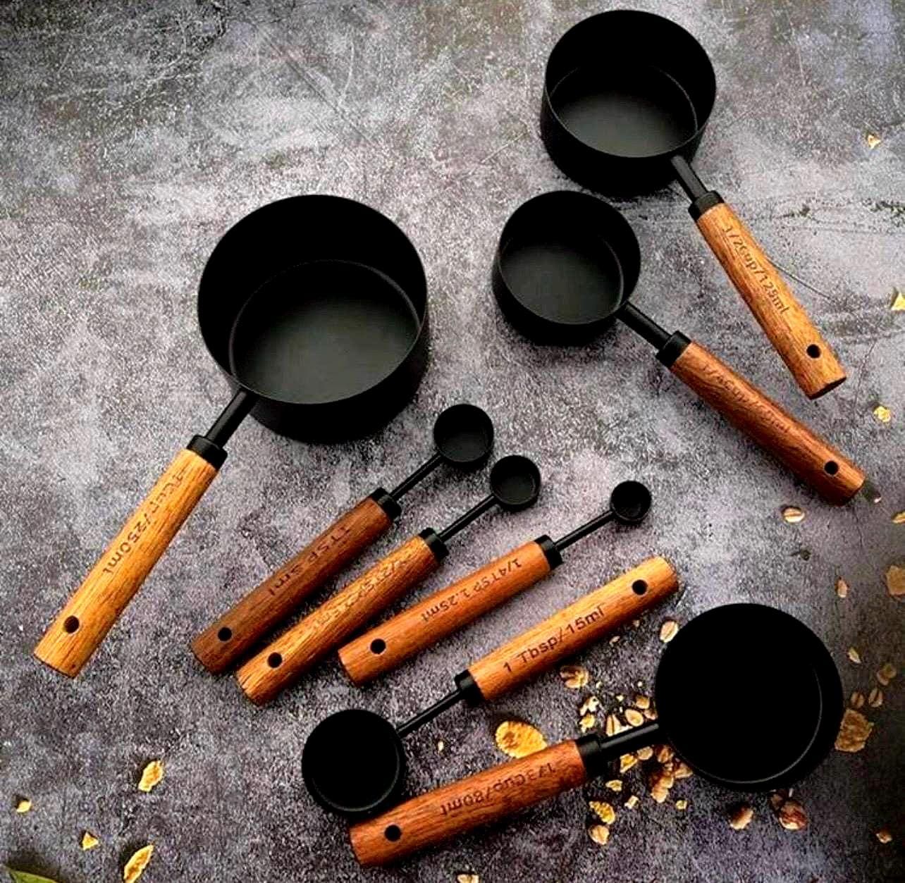 Set of measuring cups and spoons with wooden handles on a textured surface