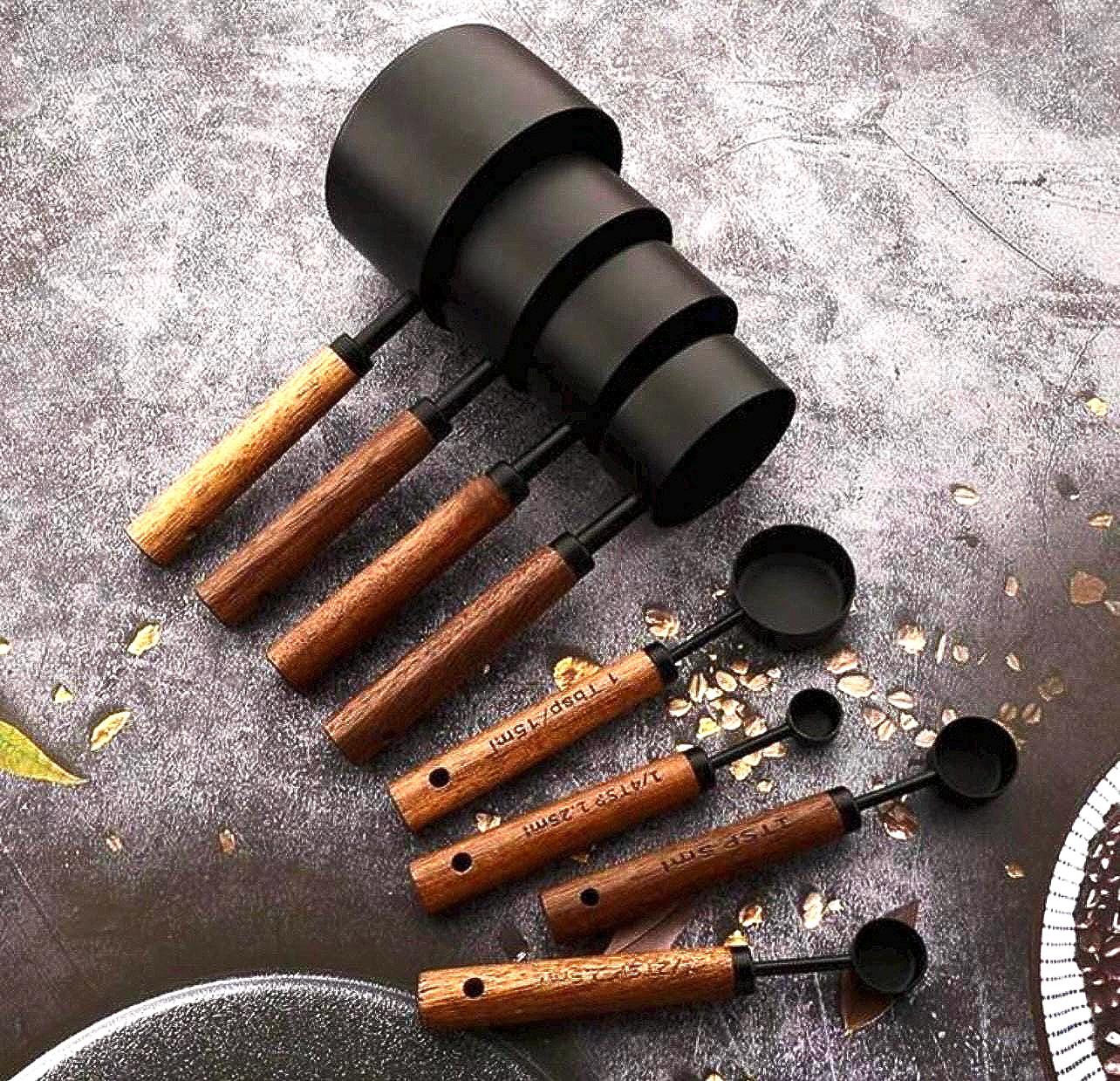 Set of black and wooden measuring cups on a textured surface